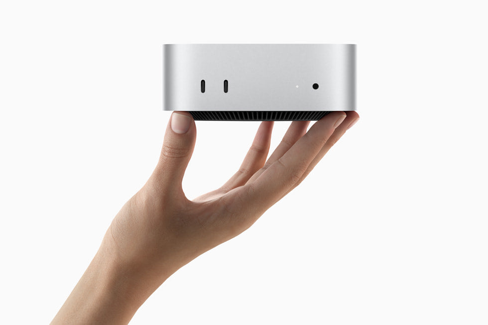 Apple Mac mini M4 hero shot - hand holding Mac mini